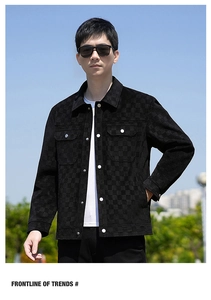 Detail of men's black suede jacket featuring damier checkered texture and metal buttons