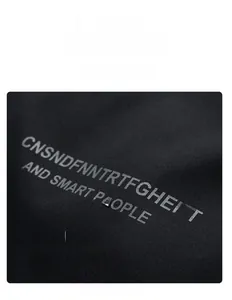 Detail of premium black cotton fabric with gray letter print on men's winter jacket