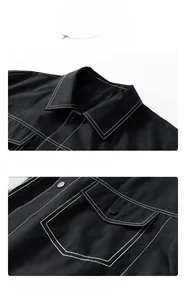 Detail view of black workwear jacket with white topstitching, lapel collar and snap pockets