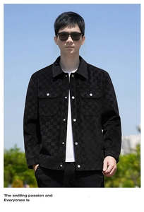 Detail of black suede checkerboard texture jacket with metal buttons and classic lapel