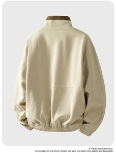 Macro detail of casual stand-collar jacket back showing beige and brown fabric texture