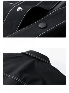 Detail view of contrast white stitching and metal snap buttons on a black twill jacket