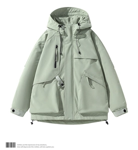 Dettaglio della giacca techwear verde chiaro con cerniere impermeabili e tasche funzionali