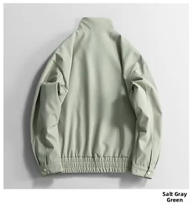Detail view of the elastic hem and cuff button on a windproof salt gray green jacket