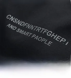 Detail shot of the grey printed letter graphics on a thick black knitted men jacket