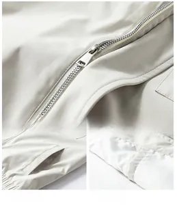 Detail view of premium metal zipper and side pockets on a beige chenille jacket