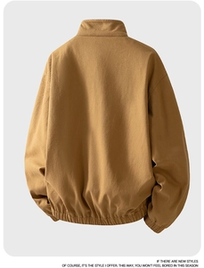 Detail view of khaki cotton jacket showing stand collar, dropped shoulders and elastic hem