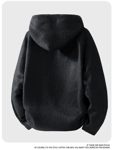 Macro detail of the fuzzy black oversized hoodie jacket showing premium wool-like texture