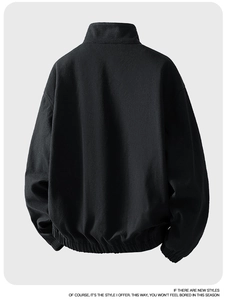 Back view of a loose-fit black stand collar jacket with elasticated gathered hem detail