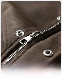 Detail view of premium metal zipper and snap buttons on vintage brown faux leather jacket