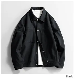 Detail of black workwear jacket with white buttons and double chest pockets