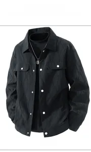 Detail view of black workwear jacket featuring vertical pleated texture and silver buttons