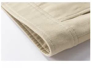 Detailed macro shot of high-density twill cotton fabric and hem stitching on beige jacket