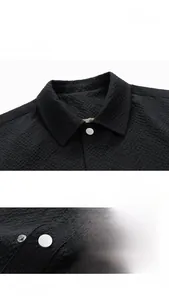 Detail of waffle textured black vintage jacket featuring turn-down collar and metal buttons