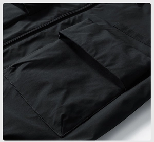 Detail of durable black cargo jacket showing heavy-duty pocket stitching and smooth zipper