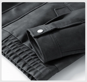 Detail view of charcoal PU leather jacket featuring silver snap buttons and elastic hemline