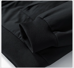 Detail shot of black bomber jacket featuring ribbed elastic cuffs and hem for wind protection