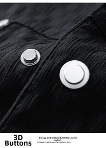 Macro detail of textured black fabric with two 3D silver metallic buttons on a jacket