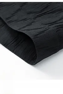 Detail view of the black wrinkled fabric hem with precision stitching on a men jacket