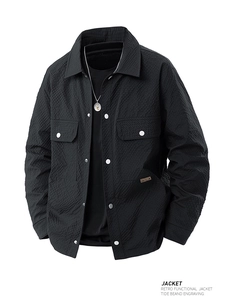 Detail view of black waffle texture jacket with silver metal buttons and large pockets