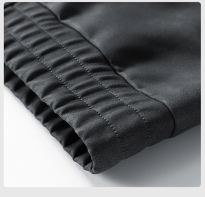 Detailed close-up of elastic hem with reinforced parallel stitching on PU leather jacket