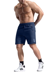 Detail of navy sports shorts featuring a zippered pocket with orange trim and elastic waist