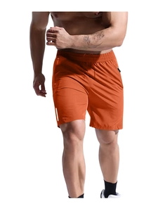 Detail of orange quick-dry sports shorts with drawstring waist and zipper pockets