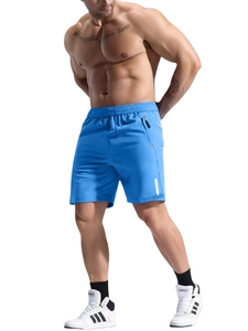 Detail view of blue athletic shorts showing elastic waistband and zipper pocket with orange accent