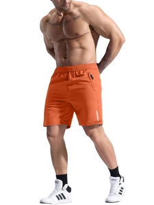 Detail of orange quick-dry sports shorts with zipper pocket and reflective strip on white back