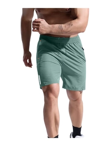 Detail of sage green sports shorts showing elastic waistband and orange zip pocket detail