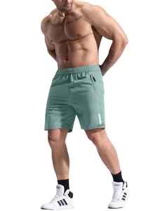 Detail of sage green athletic shorts featuring a zip pocket and reflective safety strip