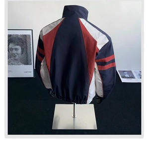 Detail of color-block stand collar jacket with elastic cuffs on a mannequin