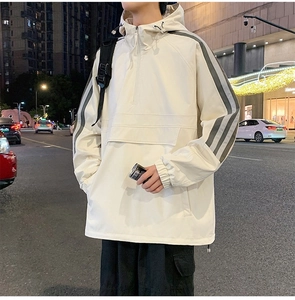 Detail view of cream-colored outdoor hooded jacket with flap cargo pocket and side stripes