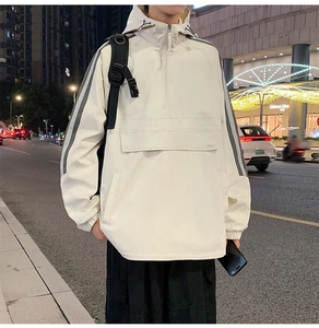 Close-up of beige half-zip windbreaker featuring reflective stripes and utility pocket