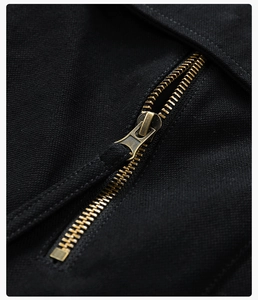Close-up of bronze metal zipper on black canvas fabric of a casual jacket