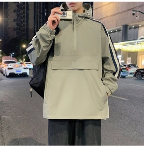 Detail of hooded windbreaker featuring kangaroo pocket and athletic sleeve stripes