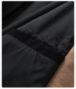 Detailed close-up showing stitching of black woven fabric and brown knit fabric on the jacket