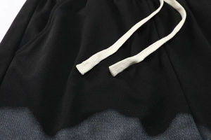 Detail view of breathable black mesh athletic shorts with thick woven drawstring and gray trim