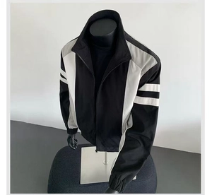 Detail of color-block jacket showing ribbed cuffs and high-neck zipper design