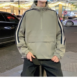 Street style shot of light green windbreaker with contrast stripes and cargo pocket