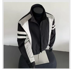 Detail of color-block casual men's jacket with stand collar and ribbed cuffs
