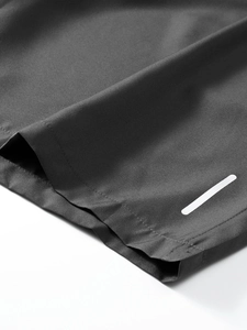 Detailed close-up of dark grey quick-dry fabric with reflective strip and premium stitching
