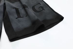 Close-up of breathable mesh fabric and IFG lettering on black athletic shorts