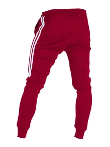 Détail macro du pantalon de jogging bordeaux avec bandes blanches et taille élastique