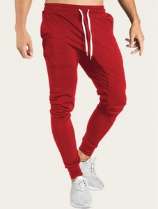 Détail du jogging rouge avec cordon blanc à la taille et chevilles resserrées