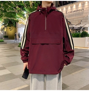 Detail of burgundy windbreaker with white sleeve stripes and front pocket flap