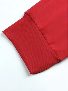 Détail du pantalon de jogging rouge avec poignets en maille côtelée et texture lisse