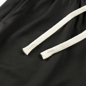 Detail of black breathable mesh sports shorts with premium off-white woven drawstrings