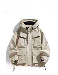 Close-up of beige techwear jacket showing waterproof fabric and multiple tactical pockets