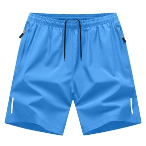 Detail view of blue quick-dry sports shorts with elastic waist, drawstrings and zip pockets